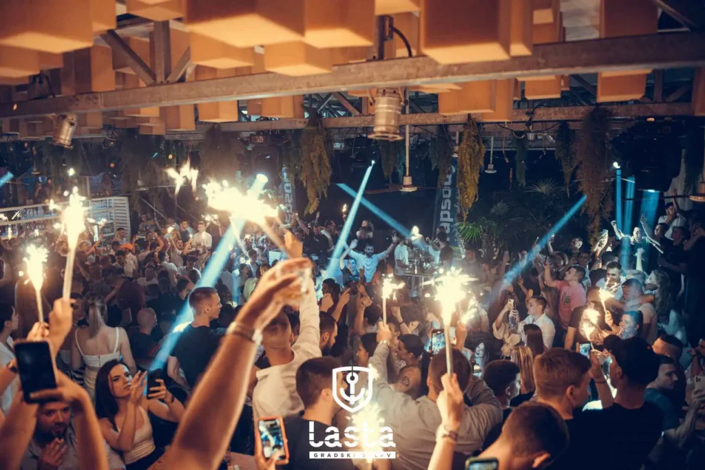 Summer Belgrade Club Lasta and people with bottle sparklers.